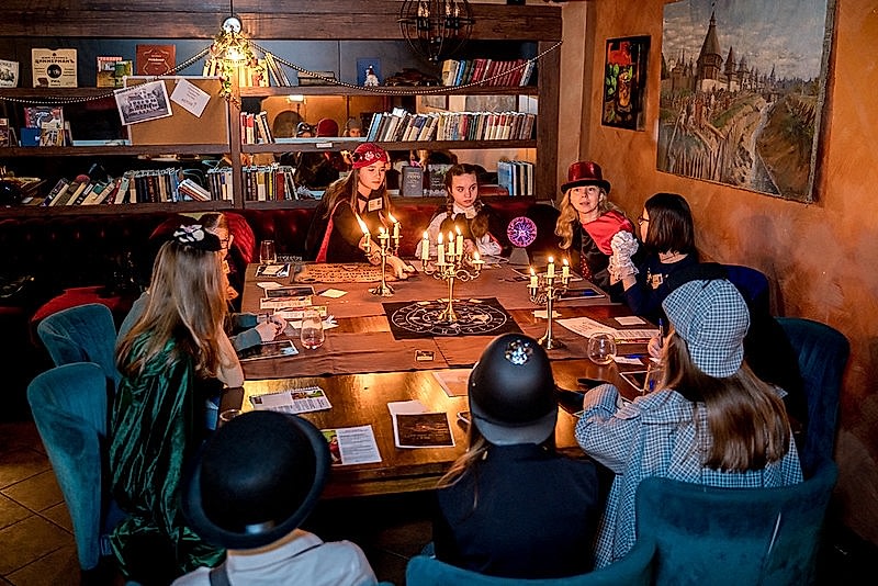 Дети разгадывают загадки в семейном квесте Хэллоуина в Алматы